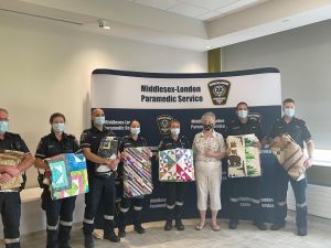 Members of Middlesex-London Paramedic Service hold up their new quilts